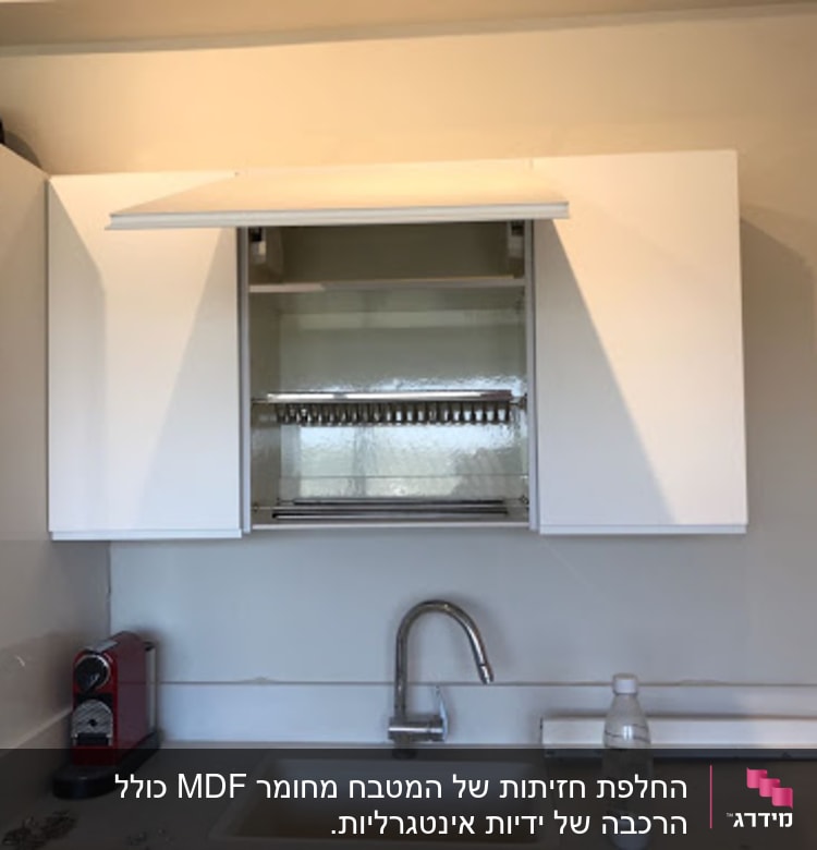 מטבח עם ארונות לבנים וברז מעל כיור
